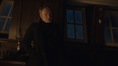 a man standing in front of a window in a dark room