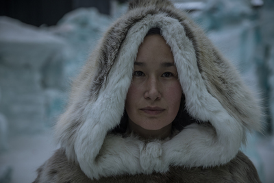 a woman wearing a fur coat with a hood over her head