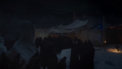 a group of people standing in the snow at night