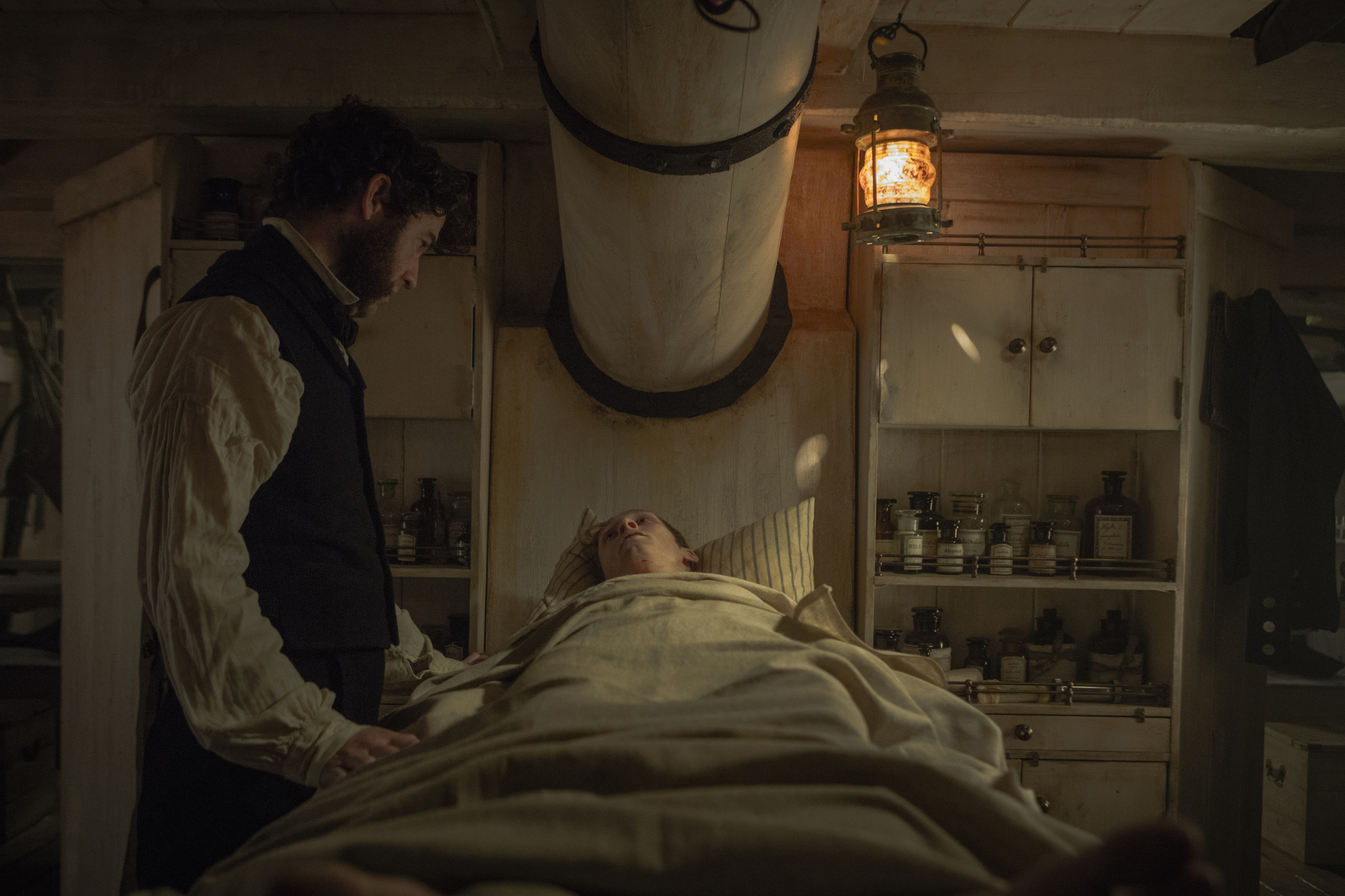 a man standing next to a woman in a hospital bed