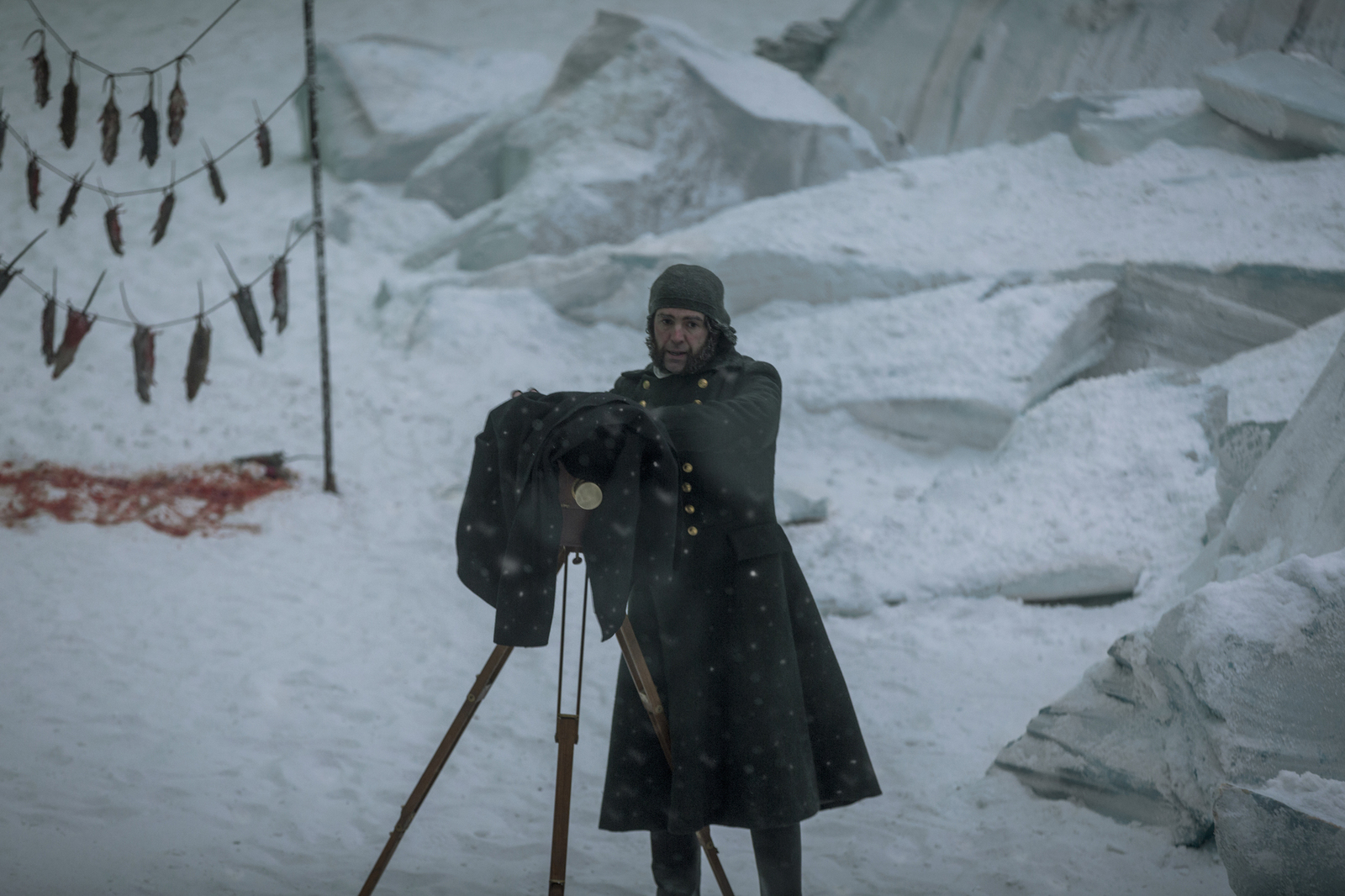 a man is standing in the snow with a pair of skis