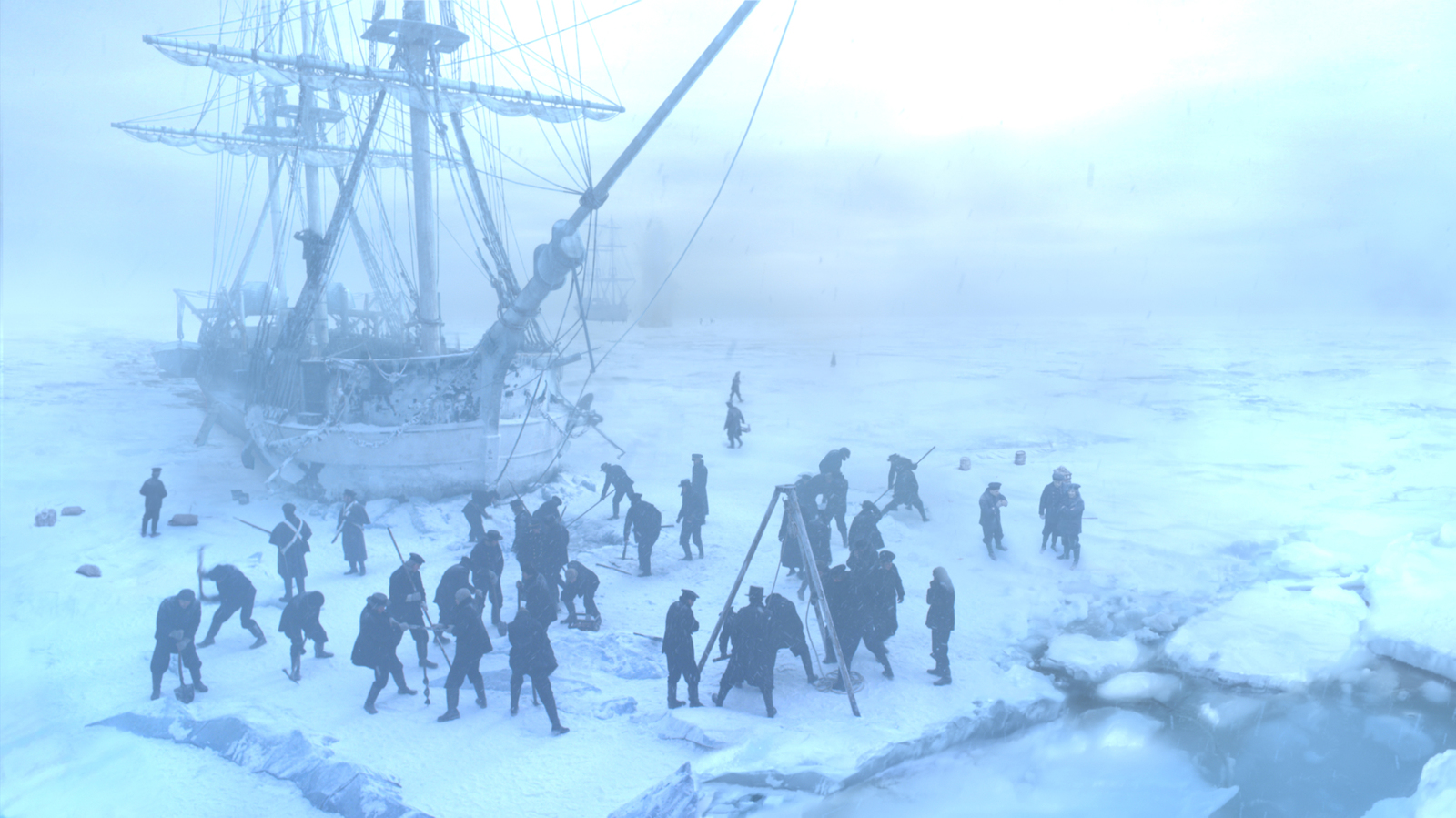 a group of people standing around a boat in the snow