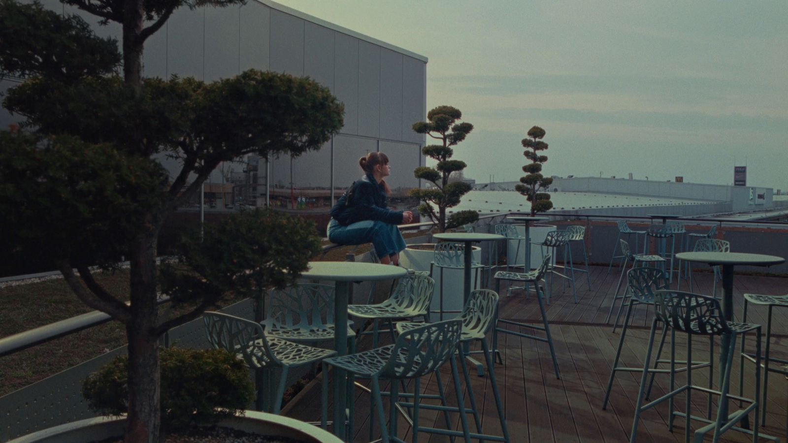 a woman sitting on top of a table next to a tree