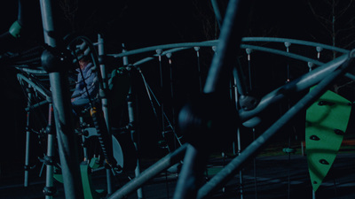 a man standing next to a playground at night