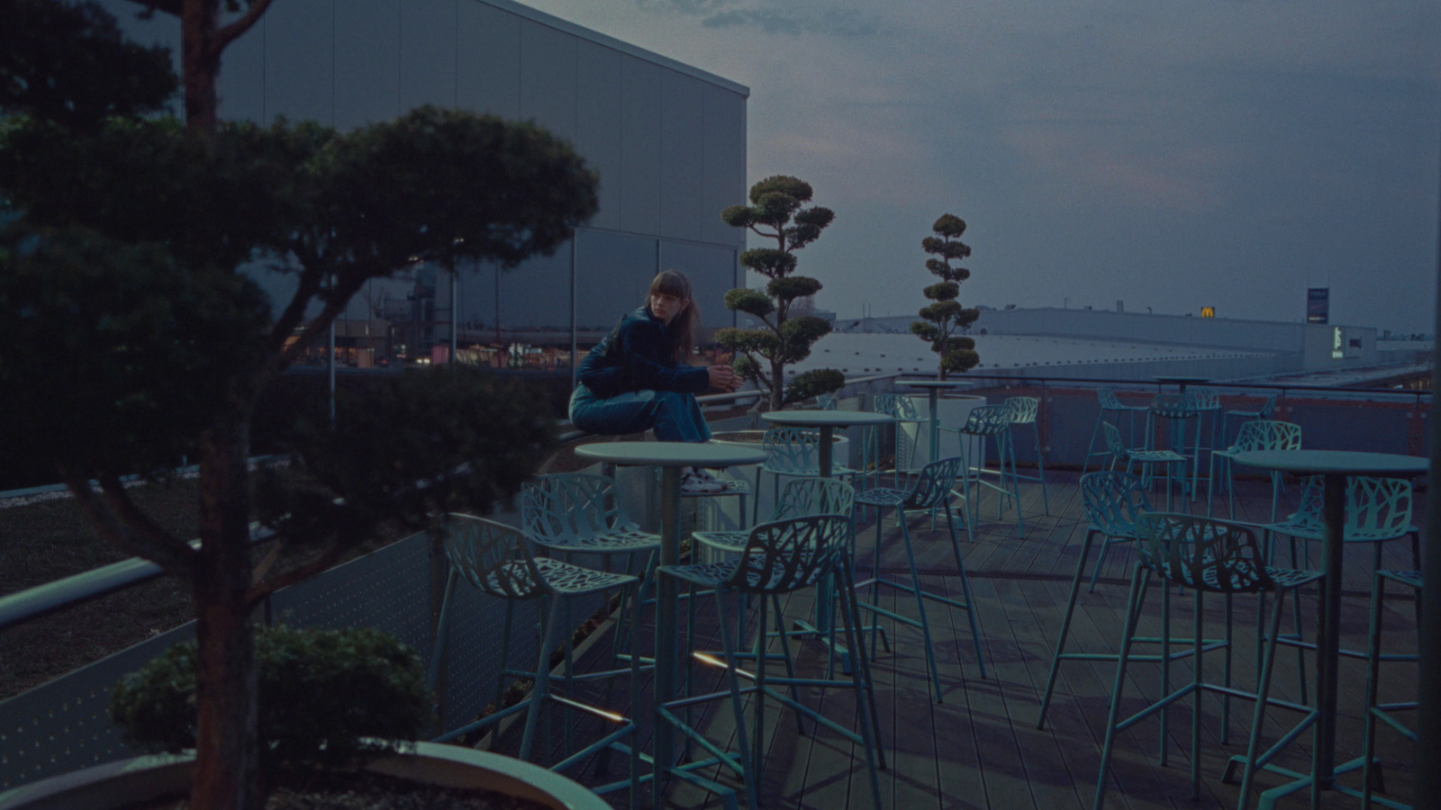 a woman sitting at a table on top of a roof