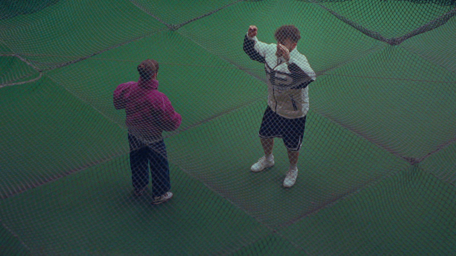 two men standing on a tennis court holding a racquet