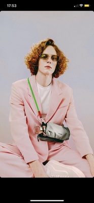 a woman in a pink suit and sunglasses