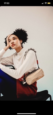 a woman sitting on a chair holding a purse