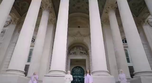 a group of women standing in front of a building