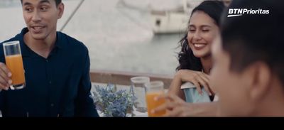 a man and a woman sitting at a table drinking orange juice