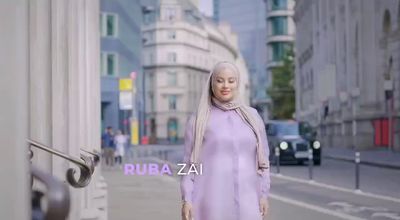 a woman in a purple dress is walking down the street