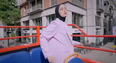 a woman wearing a hijab standing on a bus