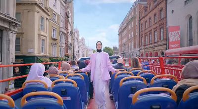 a man in a pink outfit standing on a bus