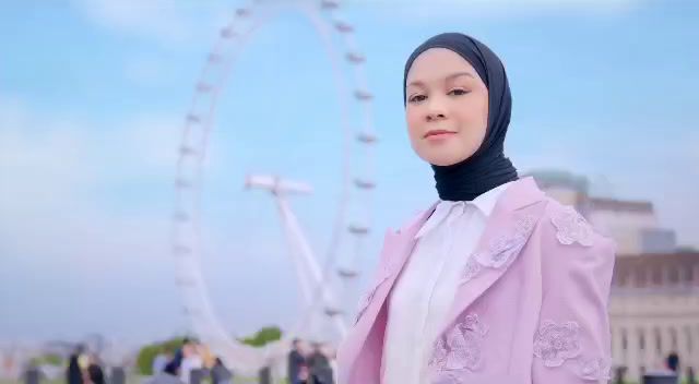 a woman standing in front of a ferris wheel