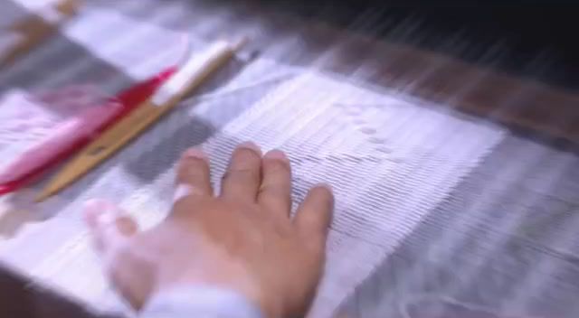 a person's hand on a piece of cloth next to a pair of scissors