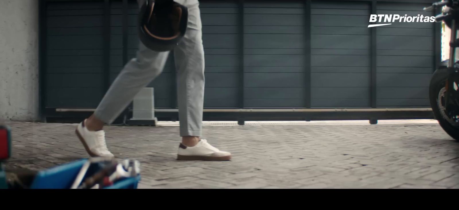 a person walking down a sidewalk next to a motorcycle