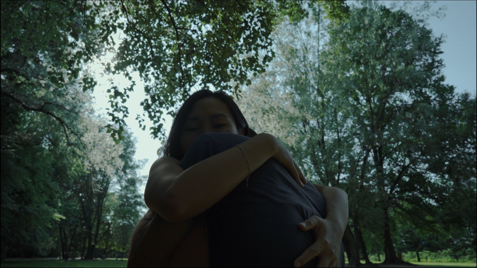 a woman holding a man in a park