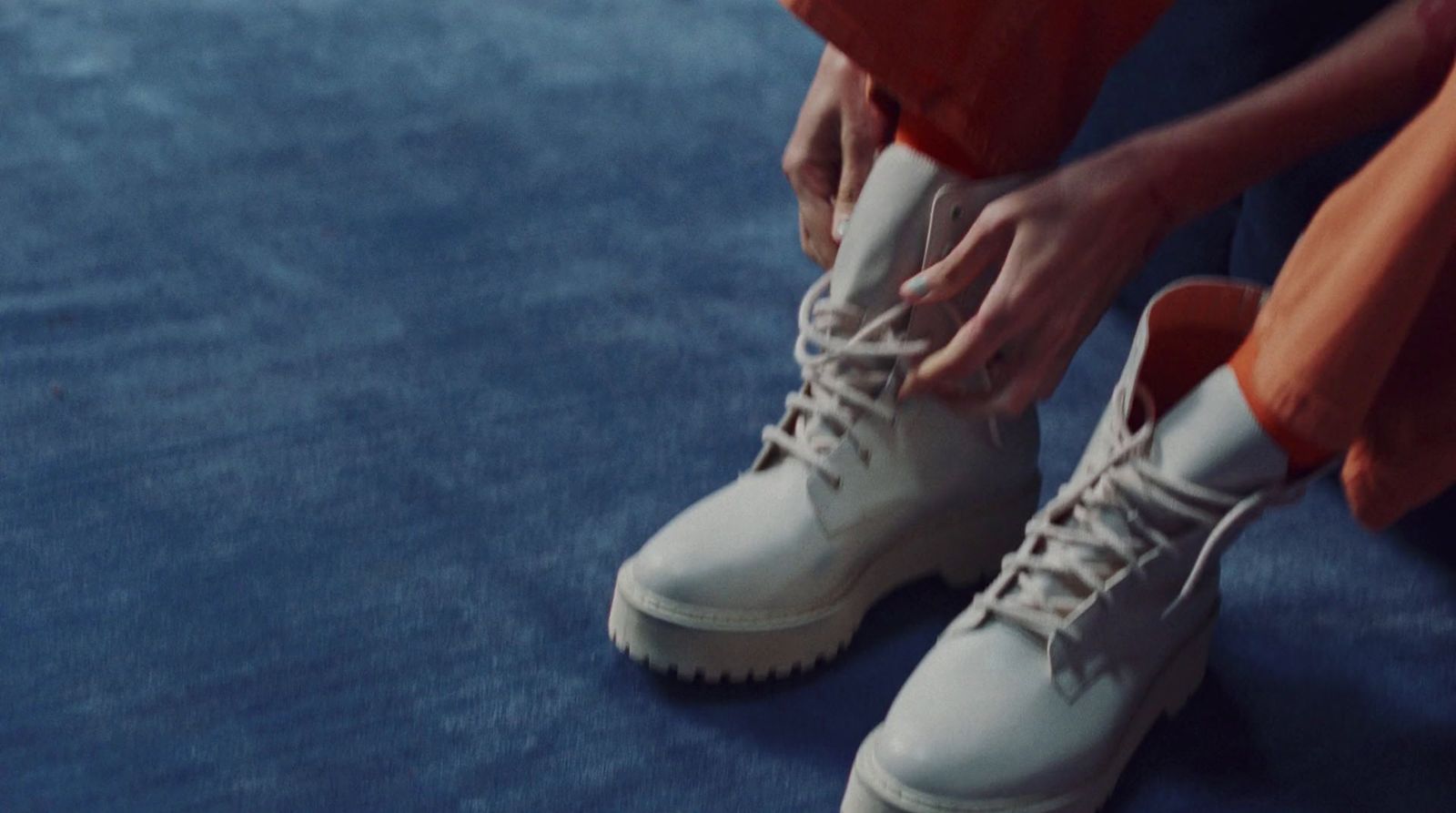 a close up of a person tying a pair of shoes