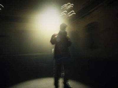 a person standing in a dark room with a light on