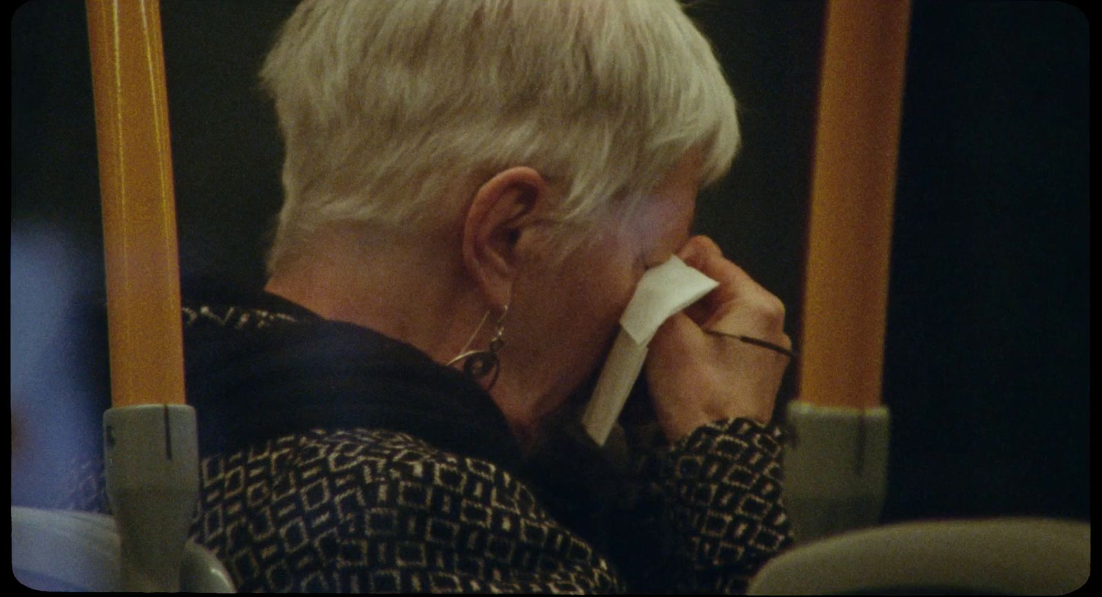 a woman sitting on a bus with her hand on her face