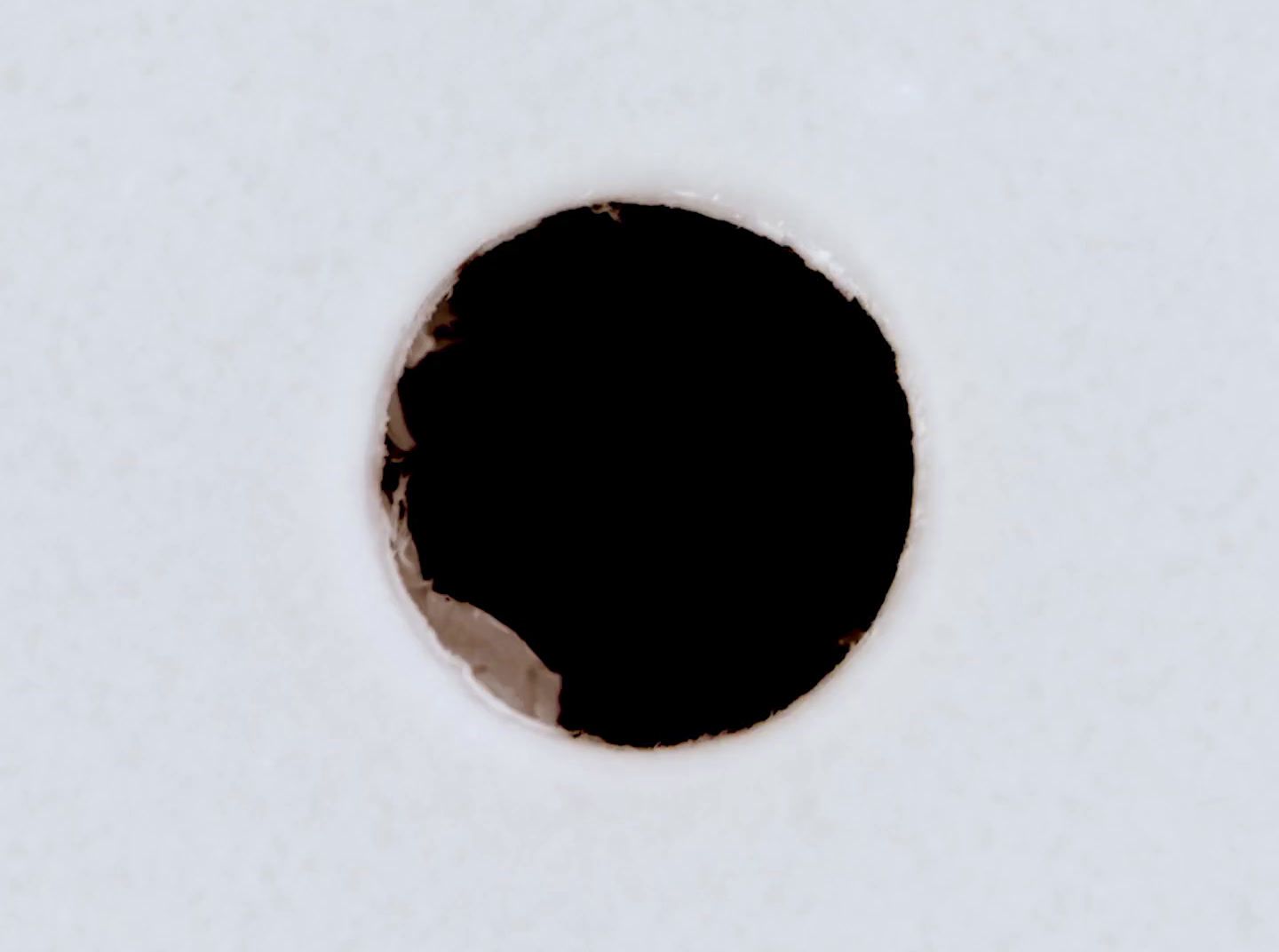 a hole in the side of a white wall