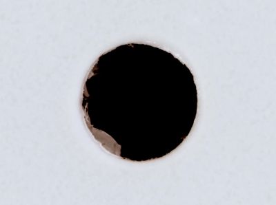 a hole in the side of a white wall