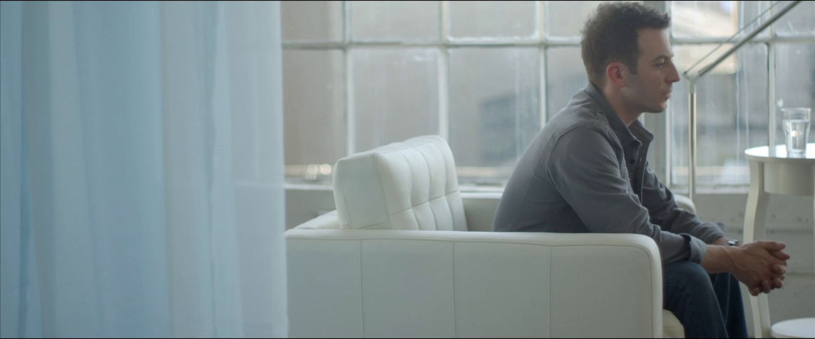 a man sitting on a white couch in a living room