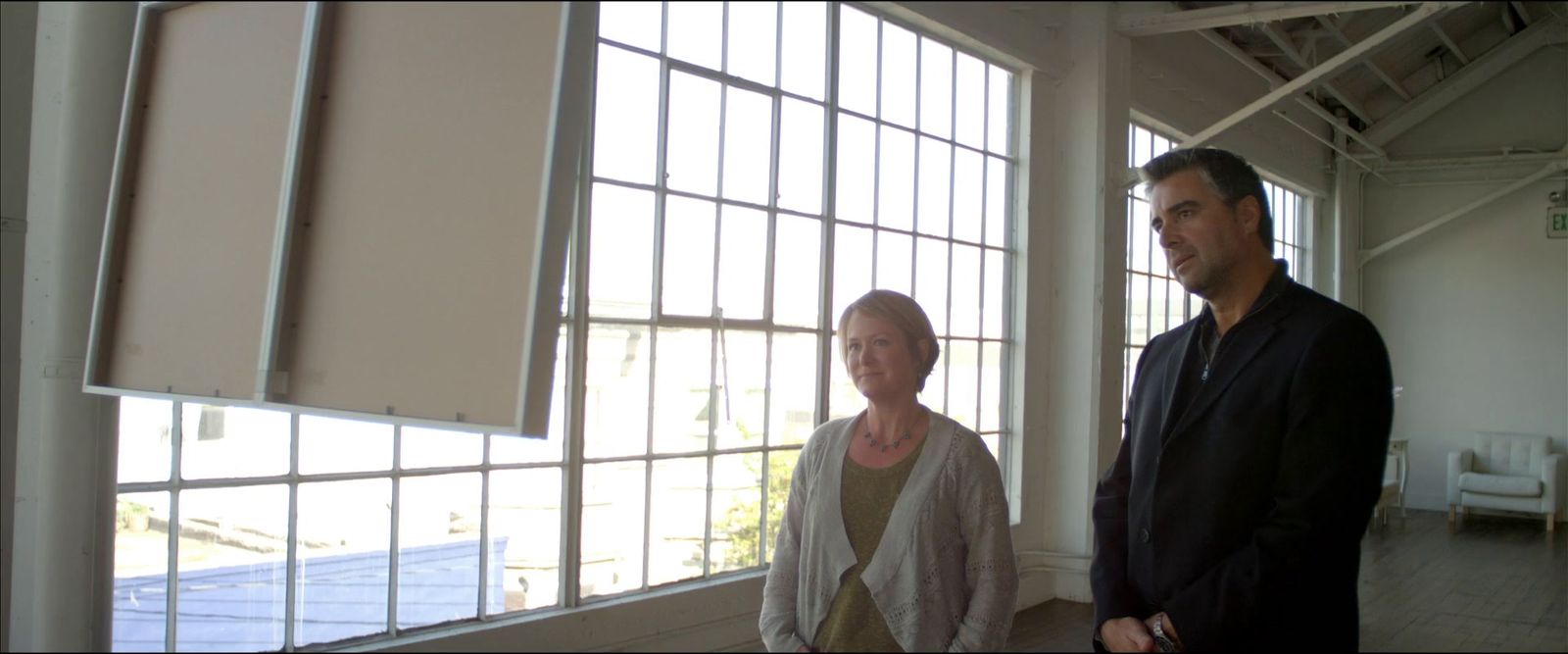 a man and a woman standing in front of a window