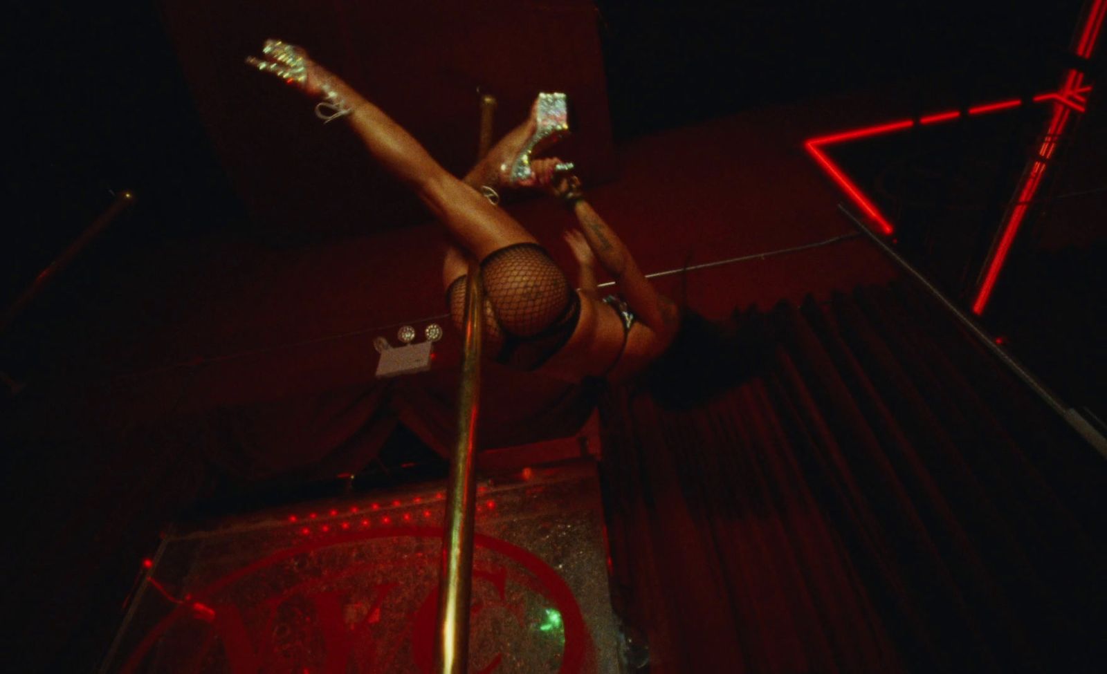 a woman in fishnet stockings and heels on a pole