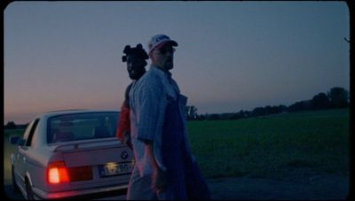 a man walking next to a white car