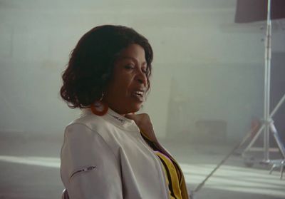 a woman in a white jacket standing in a room