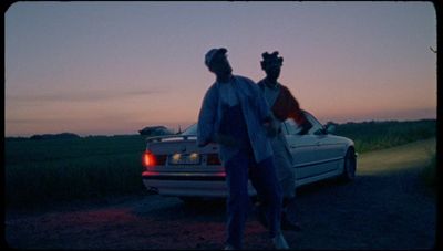 a couple of people standing next to a car