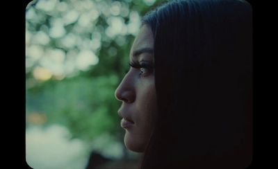 a close up of a person with a tree in the background