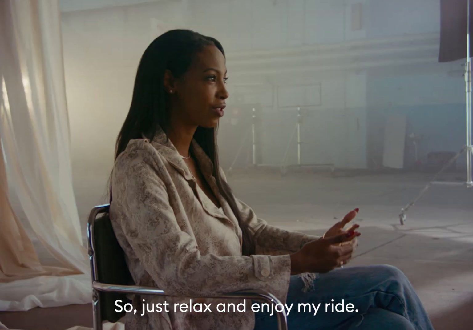 a woman sitting in a chair talking to someone