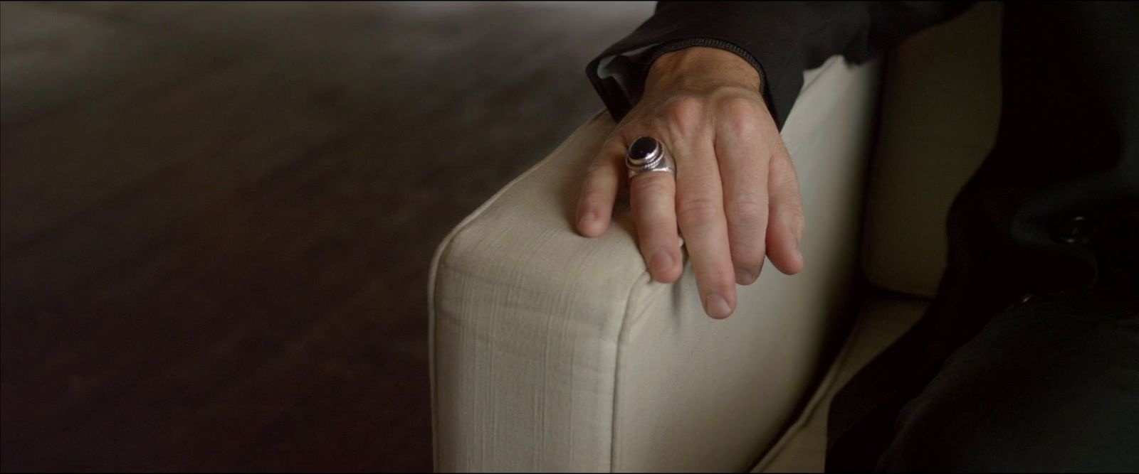 a person with a ring on their finger sitting on a couch