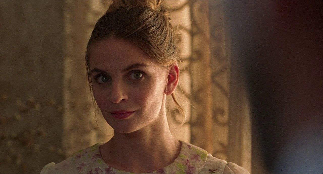 a woman in a dress looking at the camera