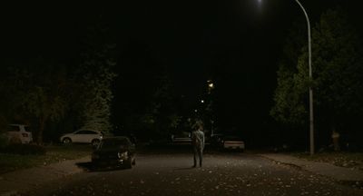 a man standing on the side of a road at night