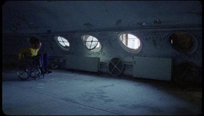 a man in a wheel chair in a room with round windows