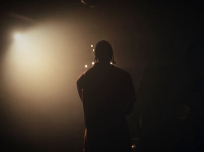 a person standing in front of a light in the dark