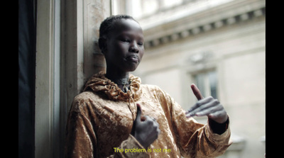 a woman standing next to a building giving a thumbs up