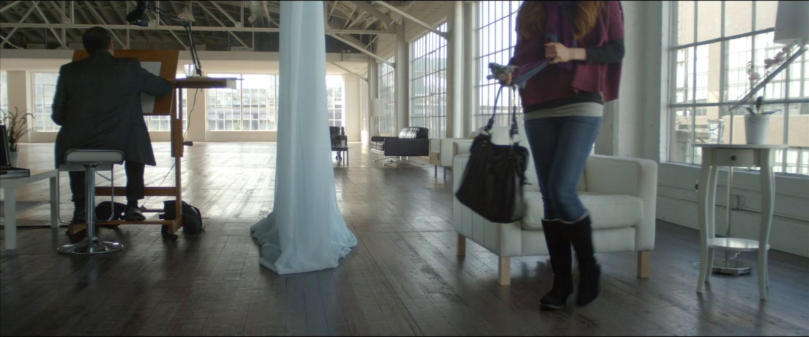 a woman standing in a room holding a purse