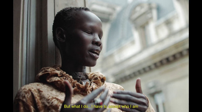 a woman standing in front of a window with her hands out