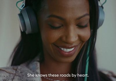 a woman wearing headphones and smiling at the camera