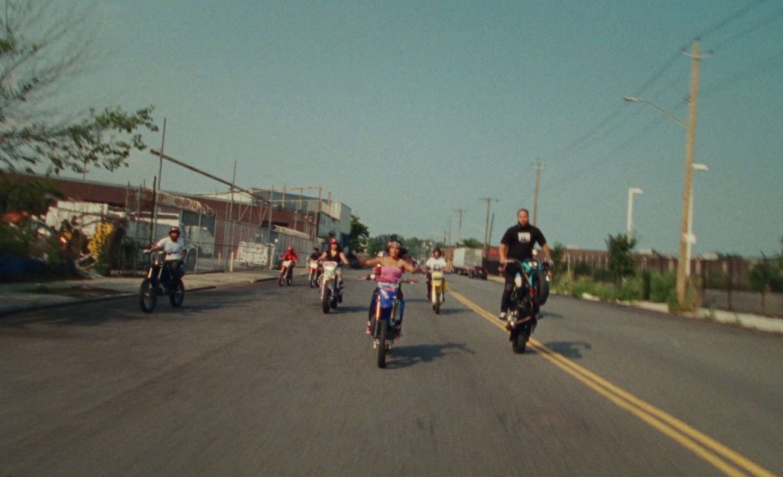 a group of people riding motorcycles down a street