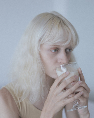 a woman with blonde hair drinking from a glass