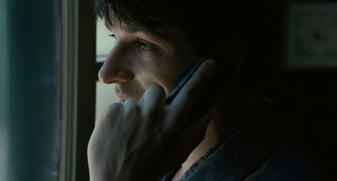 a man talking on a cell phone in a dark room