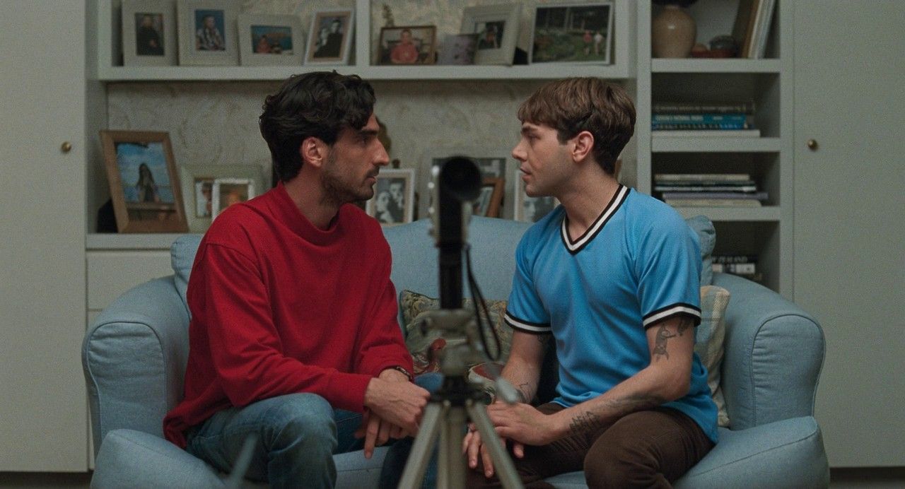 a couple of men sitting on top of a blue couch