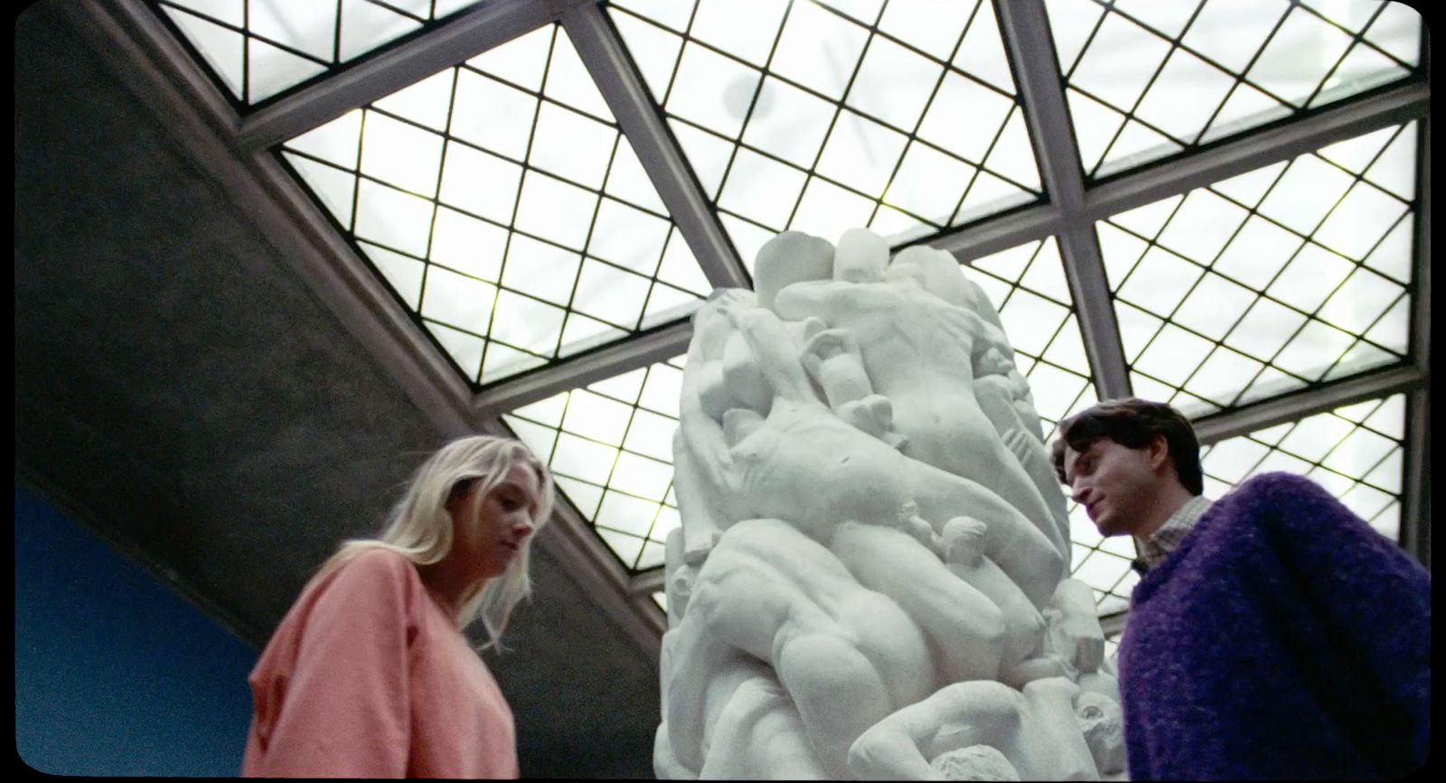 a couple of people standing next to a white sculpture