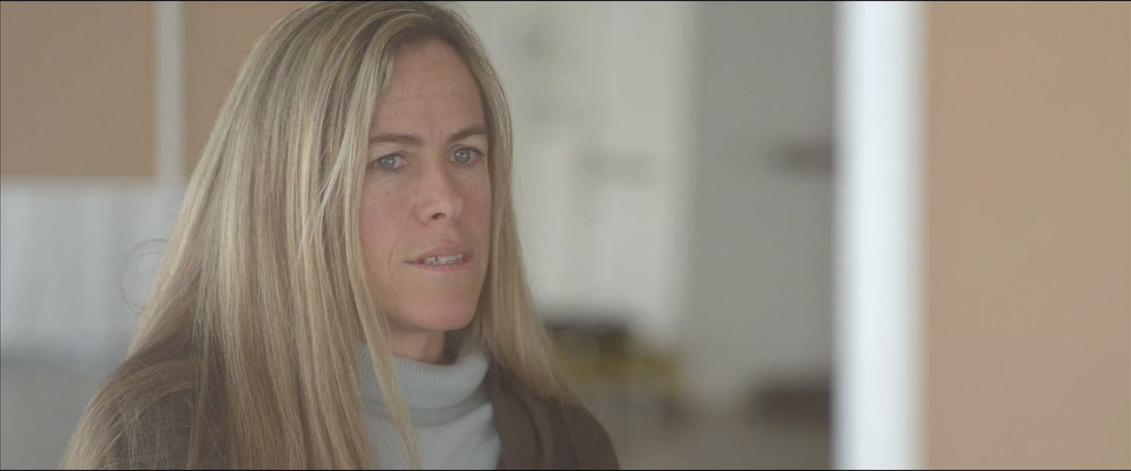 a woman with long blonde hair looking off into the distance