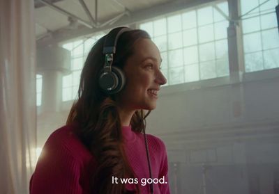 a woman wearing headphones and a pink shirt